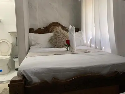 a bed with a flower in a vase on it at Hostal Marbella 47 in Cartagena de Indias
