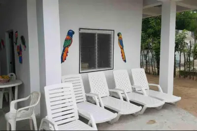 a group of white chairs sitting in front of a building at PLAYA BLANCA SANANTERO CORDOBA las palmeras D’JC in San Antero