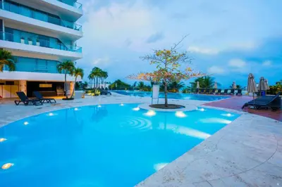 a large swimming pool with a tree in front of a building at Apartamento dentro del Hotel Sonesta Cartagena, aprovecha estar en lo mejor de MORROS in Cartagena de Indias