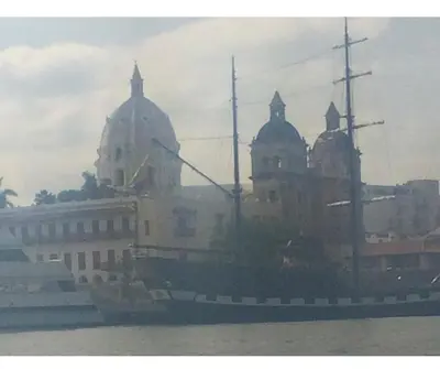 a boat in the water with a building in the background at III NICE 2 BEDROOM APARTMENT Bocagrande in Cartagena de Indias