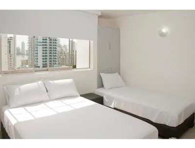 two beds in a room with two windows at III NICE 2 BEDROOM APARTMENT Bocagrande in Cartagena de Indias