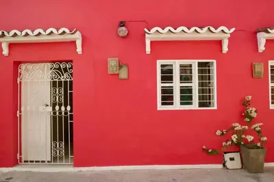 a red house with white windows and a door at GREAT LOCATION ! 4 Bedroom Home in the Heart of Cartagena in Cartagena de Indias