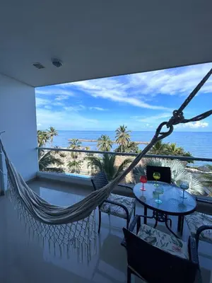 a hammock on a balcony with a view of the ocean at Hermoso Apartamento Frente al Mar 2 Habitaciones PAZ148 in Coveñitas