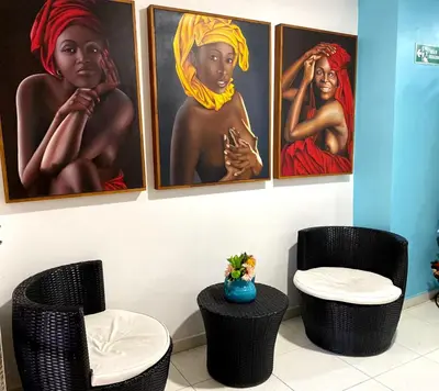 a room with three paintings of women on the wall at Luna Cartagena Airport Hotel in Cartagena de Indias