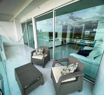 a balcony with chairs and a couch and a table at Apartamento Cartagena en Morros frente a la playa in Cartagena de Indias