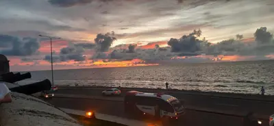a bus driving on a highway near the ocean with a sunset at Apto Nacaela-Bocagrande cerca a la playa in Cartagena de Indias