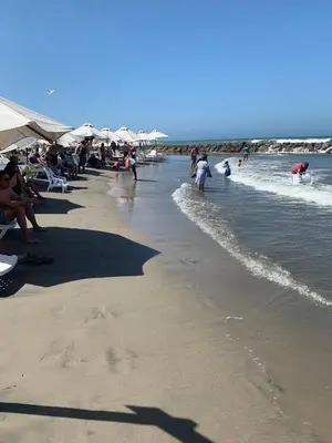 a crowd of people on a beach with umbrellas at SOL, ARENA, MAR, y PISCINA in Cartagena de Indias