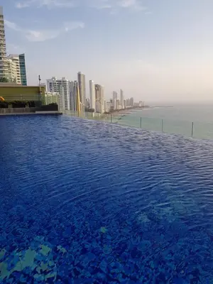 a swimming pool on top of a building with a city at H2 Hyatt Vista Mar!! in Cartagena de Indias