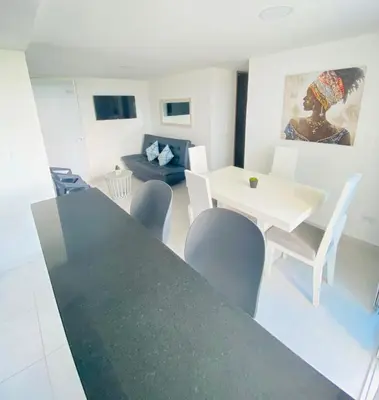 a living room with a dining room table and chairs at Hermoso Apartamento en Coveñas en unidad residencial in Coveñas