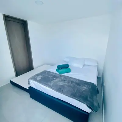a bed in a white room with a blue wall at Hermoso Apartamento en Coveñas en unidad residencial in Coveñas