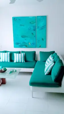 a living room with a green couch and a table at Apartamento con excelente vista al mar Dos alcobas los Morros in Cartagena de Indias