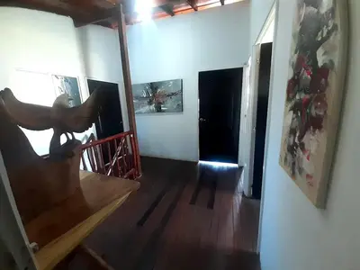 a room with a wooden staircase and a hallway with paintings at Cabaña frente al mar en moñitos, córdoba in Moñitos