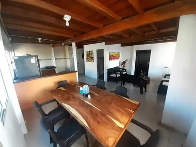 a wooden table and chairs in a room with a piano at Cabaña frente al mar en moñitos, córdoba in Moñitos