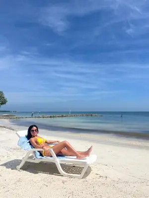 a woman laying on a beach chair on the beach at El Embrujo Tintipan in Tintipan Island