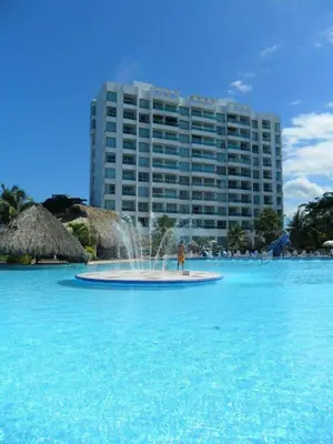 a fountain in the middle of the water in front of a building at Costazul Suites 705 in Santa Marta