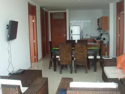 a dining room with a table and chairs and a kitchen at Costazul Suites 705 in Santa Marta