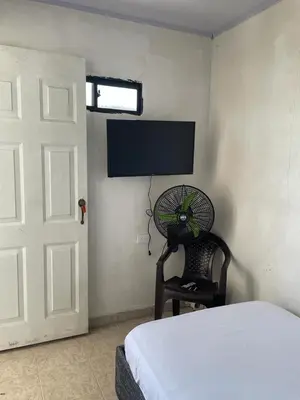 a bedroom with a bed and a fan next to a door at sophia house in Cartagena de Indias