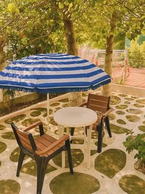 two chairs and a table with a blue and white umbrella at Casa MIKONOS in Cartagena de Indias