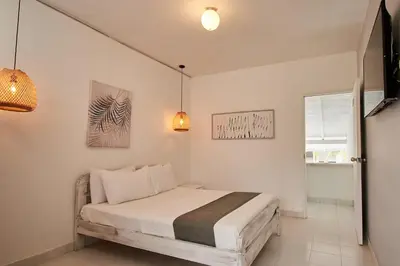 a bedroom with a bed and two pendant lights at Kpré Coveñas by Bernalo Hotels in Coveñas