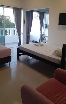 a bedroom with a bed and a couch and windows at Manglearena in Tolú