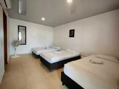 a room with three beds and a fan at Tata Lolo in Coveñas