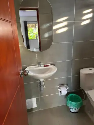 a bathroom with a sink and a mirror and a toilet at Tata Lolo in Coveñas