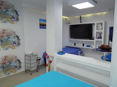 a living room with a large tv and a room with at Delfin 207 in Cartagena de Indias