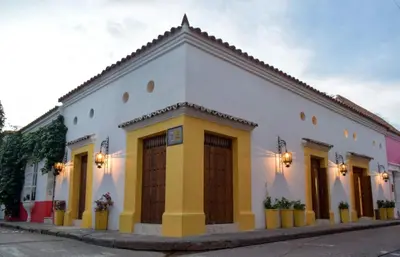 a white building with brown doors on a street at Hotel Boutique Callecitas de San Diego in Cartagena de Indias