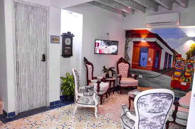 a room with chairs and a clock on the wall at Hotel Boutique Callecitas de San Diego in Cartagena de Indias
