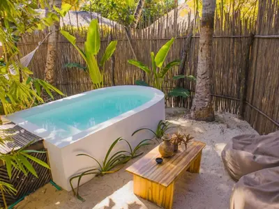 a bath tub sitting next to a wooden fence at Vista Mare Beach House in Tierra Bomba