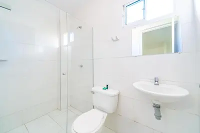 a white bathroom with a toilet and a sink at Hotel La Inmaculada in Soledad