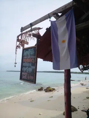 a sign and a flag on the beach at DespertArte espacio de Arte y Hospedaje in Playa Blanca