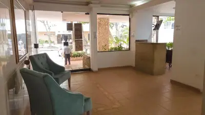 a lobby with green chairs and a man walking down a street at APARTAMENTO MARINARE DE 2 HABITACIONES CON SALIDA DIRECTA A LA PLAYA in Cartagena de Indias