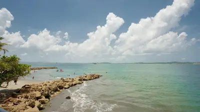 a beach with people swimming in the water at APARTAMENTO MARINARE DE 2 HABITACIONES CON SALIDA DIRECTA A LA PLAYA in Cartagena de Indias
