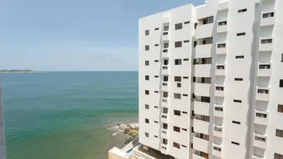 a tall white building next to the ocean at APARTESTUDIO MARINARE DE 1 HABITACION CON SALIDA DIRECTA A LA PLAYA m in Cartagena de Indias