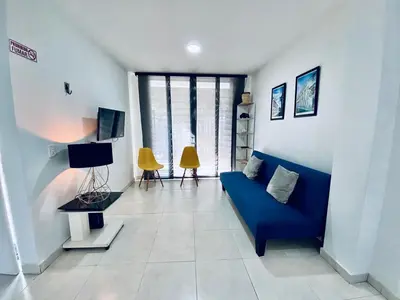 a living room with a blue couch and some windows at La palma- casa amoblada Palma Mayorca in Sincelejo