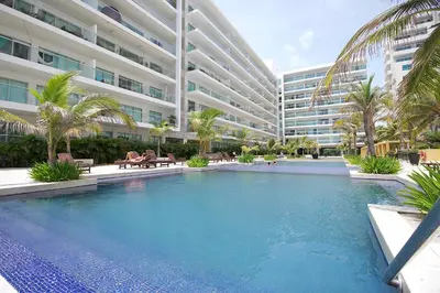a swimming pool in front of a large building at Morros Pelican Sunrise - Livin Colombia in Cartagena de Indias