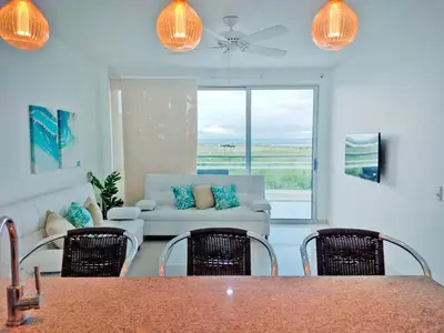 a living room with a couch and a table and chairs at Morros Pelican Sunrise - Livin Colombia in Cartagena de Indias