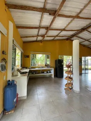 a large kitchen with a counter and a table in a room at Cabaña cerca al mar - A 200 mts in Coveñas