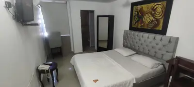 a bedroom with a bed and a painting on the wall at hotel interamericano in Barranquilla