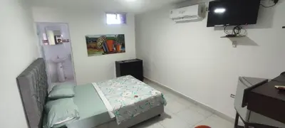 a small bedroom with a bed and a television at hotel interamericano in Barranquilla