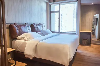 a large bed in a room with a large window at Mosaic Studios Buenavista in Barranquilla