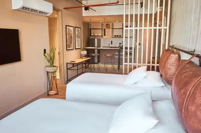 a living room with two beds and a kitchen at Mosaic Studios Buenavista in Barranquilla