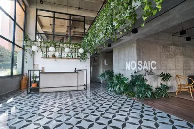 a lobby with a table and plants on the wall at Mosaic Studios Buenavista in Barranquilla