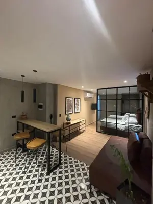 a living room with a table and a bed at Mosaic Studios Buenavista in Barranquilla