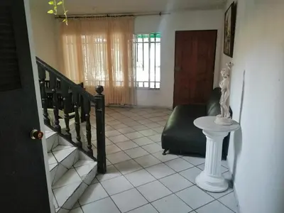 a living room with a staircase and a chair at Hospedaje Altamira in Barranquilla