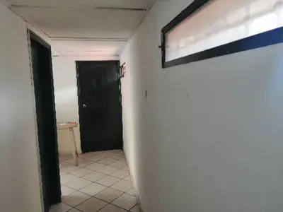 a hallway with a black door and a white wall at Hospedaje Altamira in Barranquilla