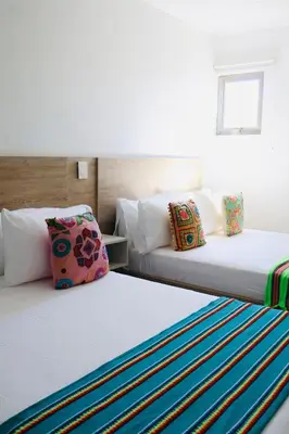 two beds sitting next to each other in a room at Hotel Coco Beach by Croma in Cartagena de Indias