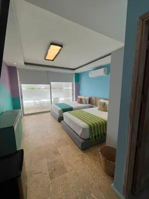 a bedroom with two beds and a couch in it at Hotel Coco Beach by Croma in Cartagena de Indias