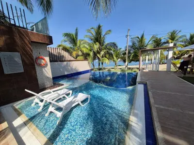 a swimming pool with two lounge chairs in a resort at Loft 39 Casa de playa in Coveñas